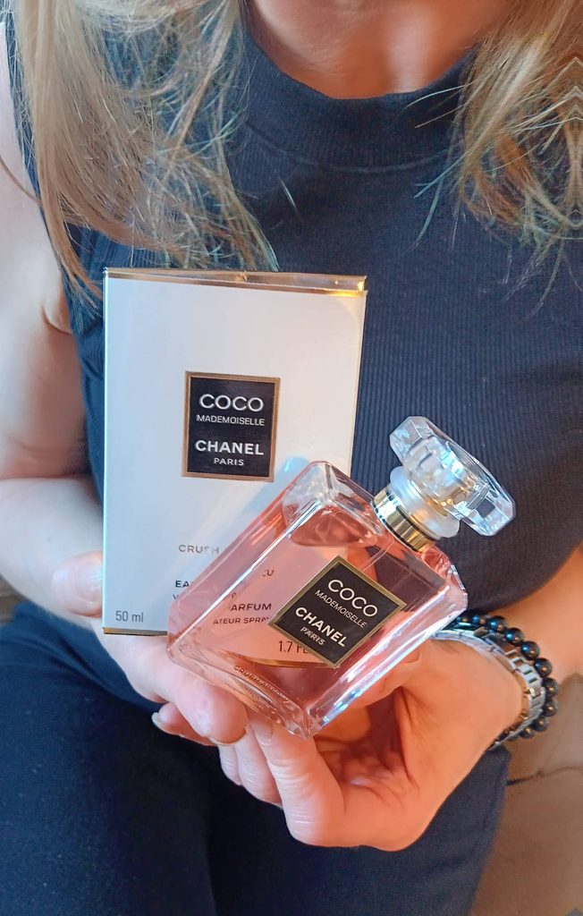 Ingrid Radford holding a bottle and box of Coco Mademoiselle Crush Absolu